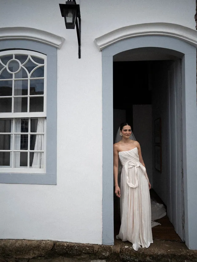 A noiva na porta de um casarão colonial de Paraty — em preto e branco