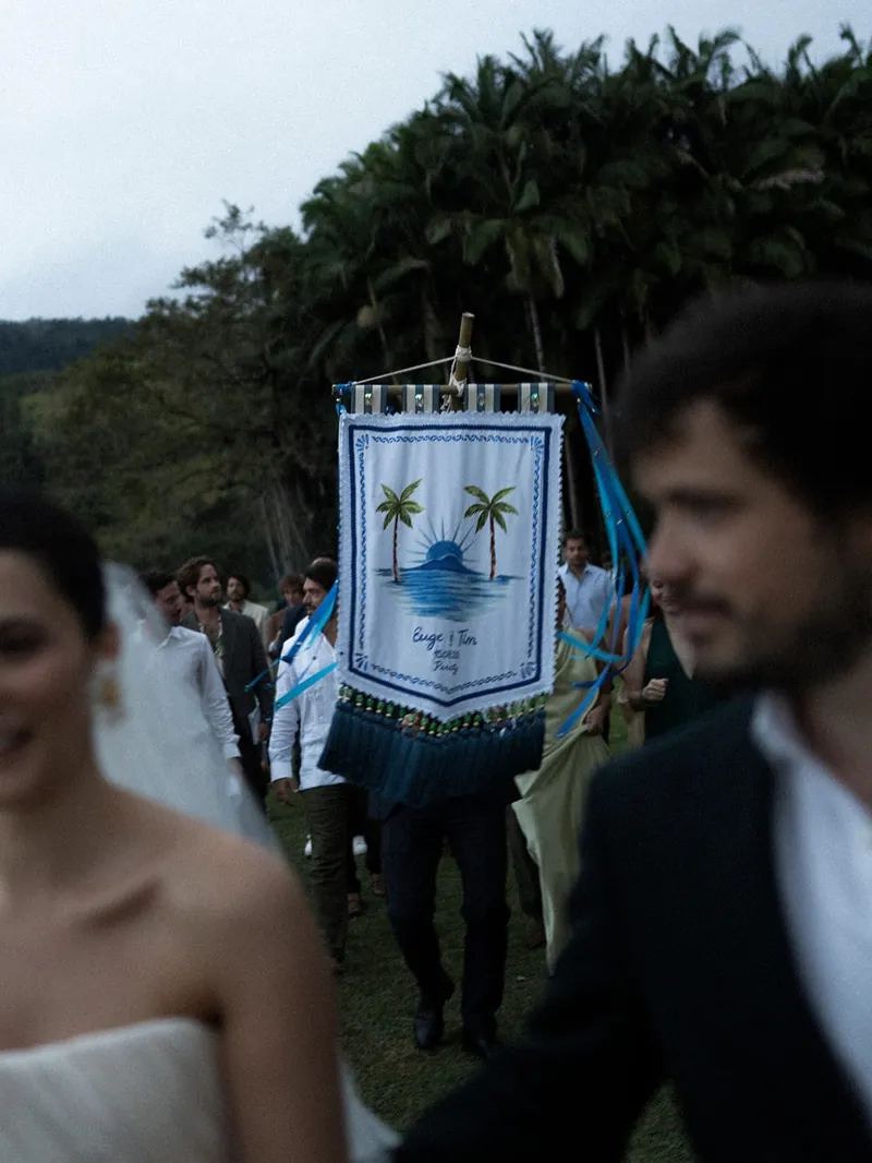 O cortejo com o estandarte, os noivos sorrindo entre os convidados